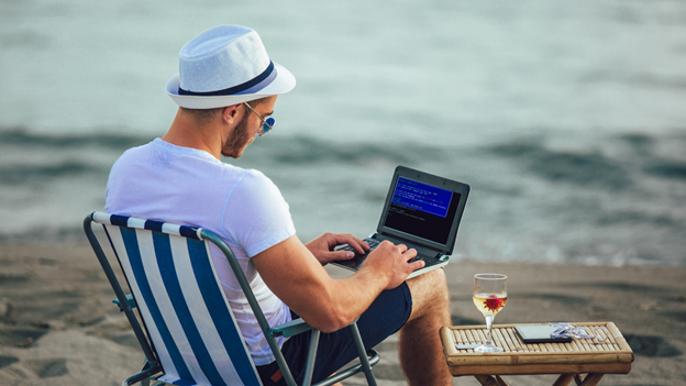 Student doing homework on the beach