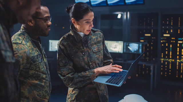 woman and men in defense industry holding laptop