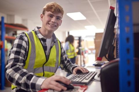 Employee working in a warehouse on a computer terminal 