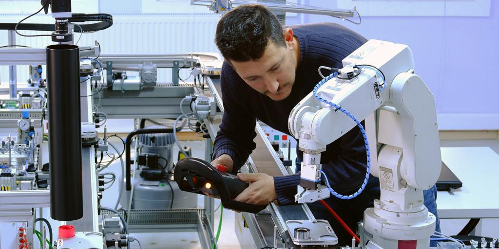 technician checking on robotic arm machine